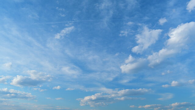Soft white clouds moving on blue sky background. Tropical summer or spring sunlight. Daytime. Time lapse.