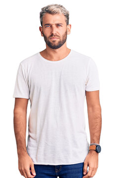 Young handsome blond man wearing casual t-shirt depressed and worry for distress, crying angry and afraid. sad expression.