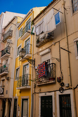 Street of Lisbon city. Washed clothes hang from the balcony and dry outside. Clothes dry on the balcony, old vintage houses, authentic architecture