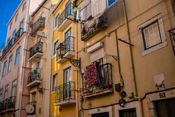 Street of Lisbon city. Washed clothes hang from the balcony and dry outside. Clothes dry on the balcony, old vintage houses, authentic architecture