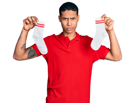 Young hispanic man holding socks skeptic and nervous, frowning upset because of problem. negative person.