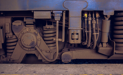 Detailed view of the underside of the locomotive: wheels, springs, various hoses and train suspension mechanisms. Close-up of the wheels, suspension and its various systems of the locomotive