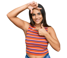 Young brunette woman wearing casual clothes smiling making frame with hands and fingers with happy face. creativity and photography concept.