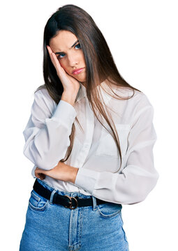 Young brunette teenager wearing business white shirt thinking looking tired and bored with depression problems with crossed arms.
