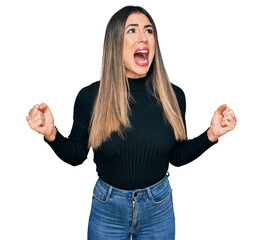 Young hispanic woman wearing casual clothes crazy and mad shouting and yelling with aggressive...
