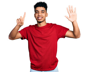 Fototapeta premium Young african american man wearing casual red t shirt showing and pointing up with fingers number six while smiling confident and happy.