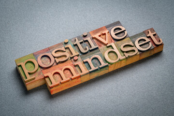 Naklejka premium positive mindset - text in retro letterpress wood type stained by color inks, attitude, positivity and personal development concept