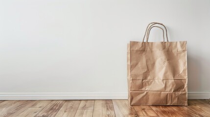 Paper bag placed on wooden floor in front of white wall