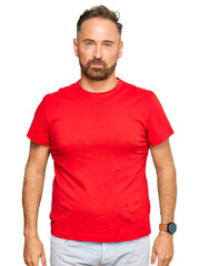 Fototapeta premium Handsome middle age man wearing casual red tshirt depressed and worry for distress, crying angry and afraid. sad expression.