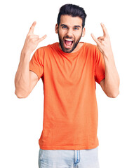 Young handsome man with beard wearing casual t-shirt shouting with crazy expression doing rock symbol with hands up. music star. heavy music concept.