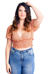 Fototapeta premium Beautiful young brunette woman wearing casual clothes confuse and wonder about question. uncertain with doubt, thinking with hand on head. pensive concept.