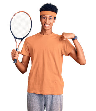 Young african american man playing tennis holding racket pointing finger to one self smiling happy and proud