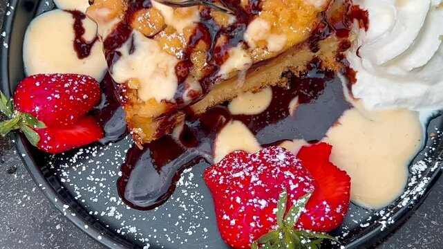 Apple strudel with strawberries ice cream and whipped cream topped with caramel syrup and chocolate. High quality 4k footage