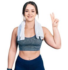 Young hispanic girl wearing sportswear and towel showing and pointing up with fingers number two while smiling confident and happy.