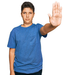 Teenager hispanic boy wearing casual clothes doing stop sing with palm of the hand. warning expression with negative and serious gesture on the face.