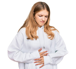 Beautiful young caucasian girl wearing casual sweatshirt with hand on stomach because indigestion,...
