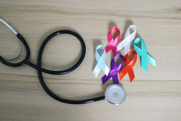 Flat Lay Of Colorful Ribbons With Stethoscope Over Wooden Background. World Cancer Day