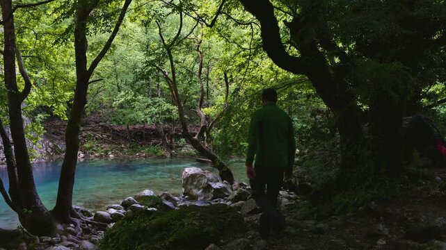 A tranquil view of the turquoise waters of the Voidomatis River, flowing through the dramatic landscape of Vikos Gorge in Greece.