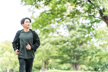 公園でジョギング・ランニングする若いアジア人男性
