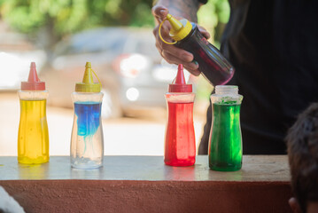 Small bottles full of colors yellow, blue, red and green.