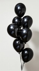 Black balloons on white background, minimalist aesthetic. Celebration and party concept