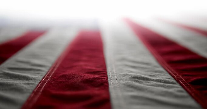 Panning across a brightly lit, red white and blue, US American flag and slowly fading to white. Background for Memorial Day, Veteran's Day, 4th of July, or other patriotic USA holiday.