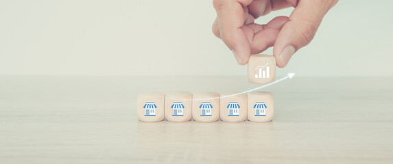 Hand choose wooden stack pyramid with franchise icon for investment planning growth financial and...