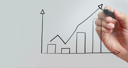 Male hand drawing graph chart showing business profit growth increasing