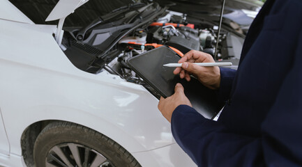 After a car accident, an insurance agent inspects the damaged vehicle. The agent takes photos, examines the wreck, and writes a report for repair claims. The injured driver seeks emergency help.