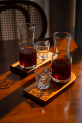 V60 black coffee serving set, using indonesian puntang arabica coffee bean, served on beautiful transparent glass. Cozy cafe environment, on wooden table surface