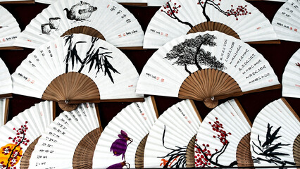 KOREA, SEOUL – April 2024: painted hand fan with various asian drawing isolated on white paper,...