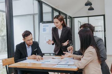 Professional team, including businessmen and businesswomen, engages in a strategy meeting. They discuss marketing, analyze financial data, and brainstorm investment plans using charts, graphs,