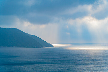 The rays of the sun through the clouds over the sea.  A natural phenomenon over an island in the sea. Vietnam, the South China Sea. 