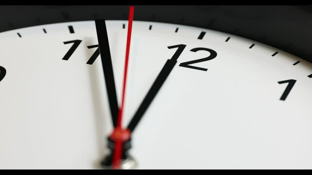 Clock face 4K UHD real time footage at 12 noon or 12 AM. Red second pointer clicks. Clock time ticking on a classic Wall Clock. Shadows moving over the Watch. Half of a Clock dial close-up isolated. 