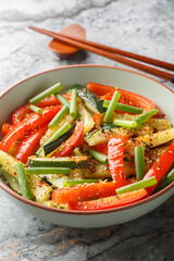 Stir fry zucchini and bell pepper close-up in a bowl on the table. Vertical