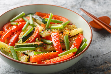 Asian vegetable stir fry of zucchini, green onions and bell pepper close-up in a bowl on the table. Horizontal