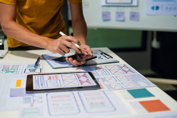 UX developer and ui designer brainstorming about mobile app interface wireframe design with...