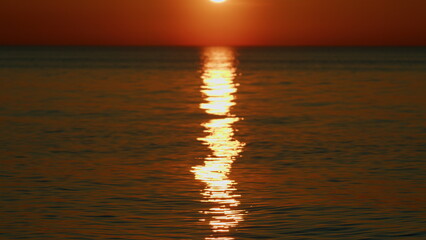 Sun Reflects And Sparkles On Waves With Bokeh Lights. Evening Sun Glare On Water. Slow motion.