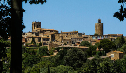 Scenic view of the medieval town of Pals, Spain, with historic stone buildings and a clear blue sky.