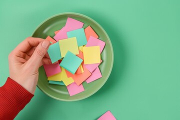 A person holding a piece of paper with colorful sticky notes on it. AI.