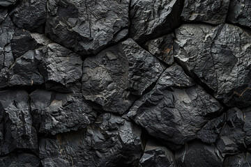A black rock wall with a rough texture