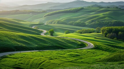 Fototapeta premium Green fields and hills in spring with a highway curving through the landscape