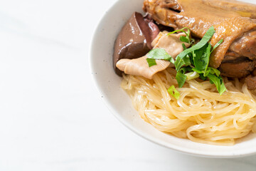 dried noodles with braised duck in white bowl