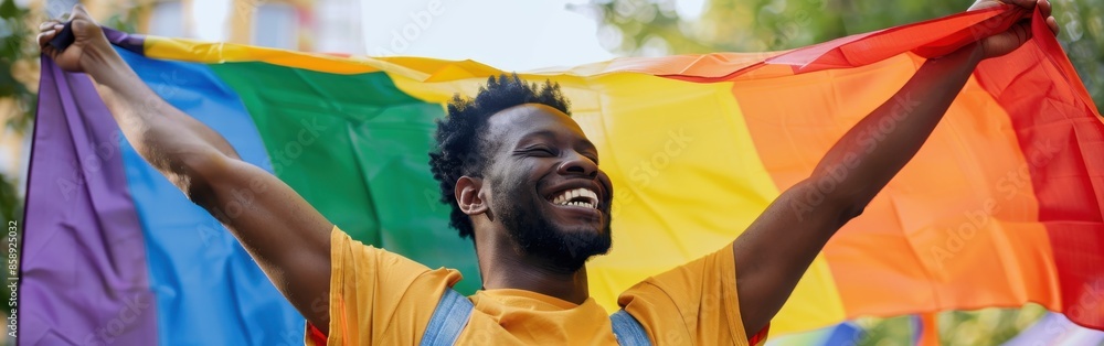 Poster a man is holding a rainbow flag and smiling. the flag is colorful and vibrant, representing the lgbt