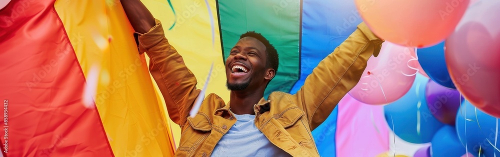 Poster A man is jumping in the air with a rainbow flag behind him. He is surrounded by many balloons of different colors