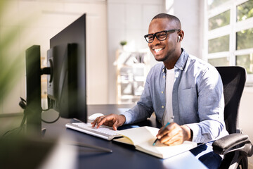 Young African American man using desktop computer for online webinar course