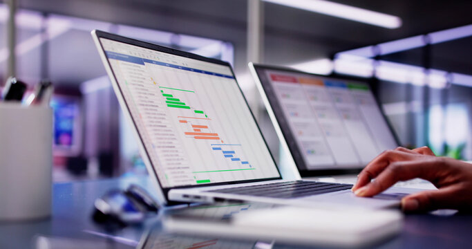 African American woman using laptop to manage multiple tasks and projects - Powered by Adobe