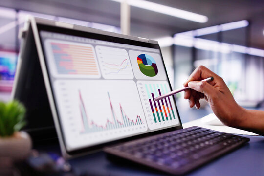 African American woman analyzing financial data on laptop screen