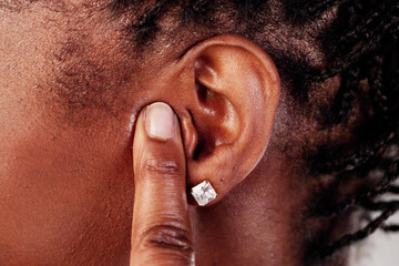 Woman in discomfort covering ear due to painful sound, prompting a visit