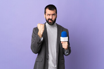 Adult reporter man with beard holding a microphone over isolated purple background with unhappy...